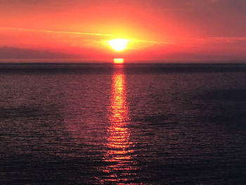 Scenic view of sea against romantic sky at sunset