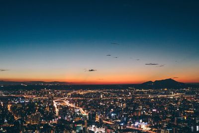 Illuminated cityscape against sky at night