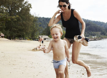Mother running with son on beach
