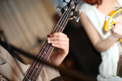 Midsection of woman playing guitar