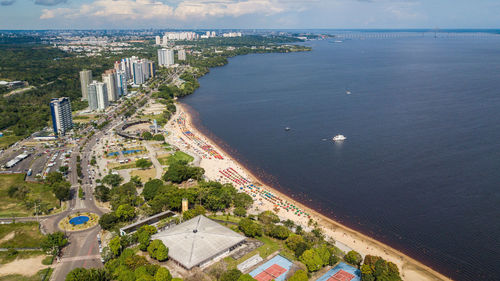 High angle view of city by sea against sky