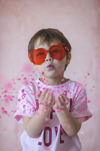 Portrait of cute girl standing against wall