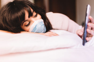 Midsection of woman lying on bed