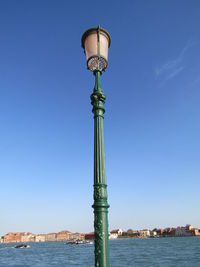 Street light against blue sky and buildings