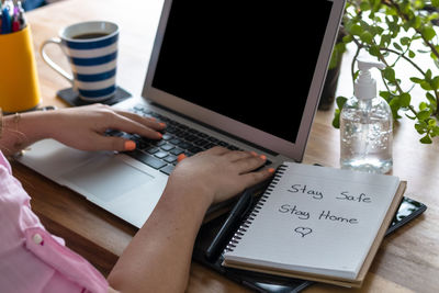 Midsection of man using laptop on table