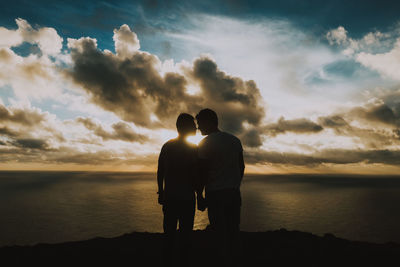 Rear view of silhouette man standing against sky during sunset