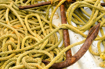 High angle view rope by rusty anchor on boat