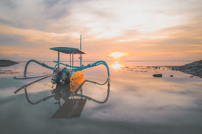 Boat in sea against sky during sunset