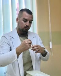 Dentist holding dental equipment at clinic