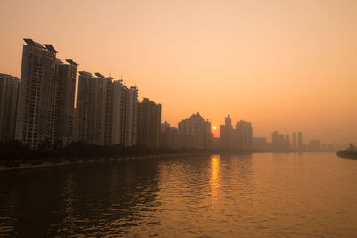 City buildings against clear sky during sunset