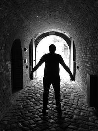 Silhouette of man standing in tunnel