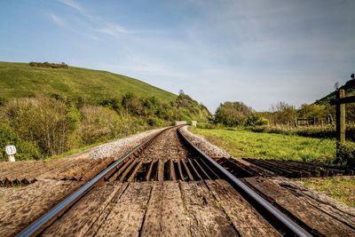 Railroad track passing through land against sky