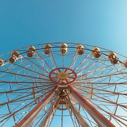 Low angle view of ferris wheel against blue sky