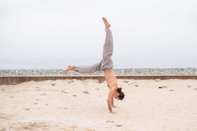 Rear view of woman jumping on beach