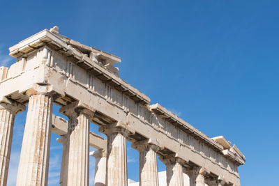 Low angle view of acropolis against clear sky during sunny day