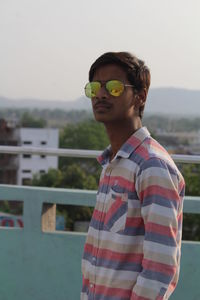 Man standing on building terrace against sky