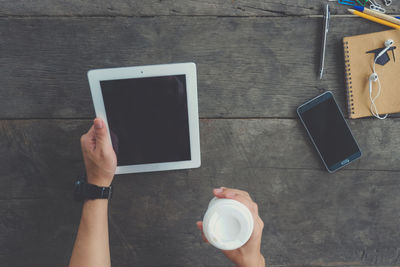 Low section of person holding smart phone on table