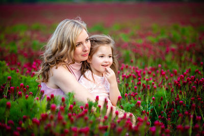 Cute girl with pink flower petals on land