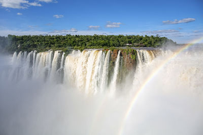 Scenic view of waterfall against sky