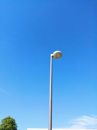 Low angle view of street light against blue sky