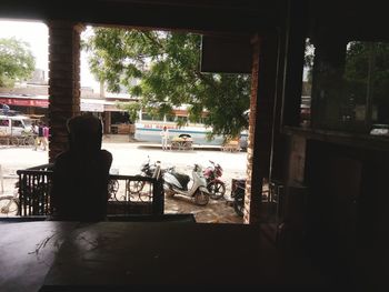 Rear view of man sitting by window in building