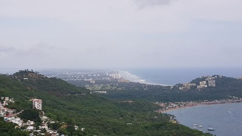 High angle view of city by sea against sky