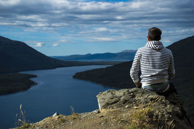 Rear view of man looking at mountain against sky