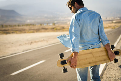 Rear view of man standing on road