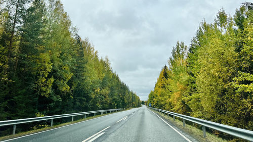 Road amidst trees against sky