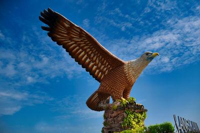 Low angle view of eagle flying against sky