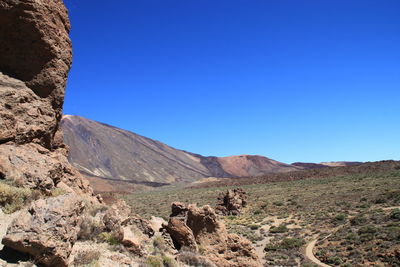 Scenic view of rocky mountains against clear blue sky