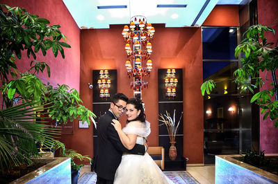 Couple standing in illuminated room