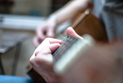 Close-up of hands of a man playing guitar