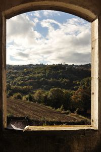 Scenic view of landscape against sky seen through window