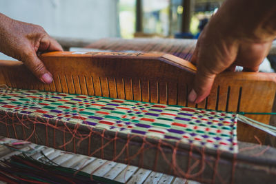 Cropped hands weaving loom