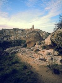 Built structure on rock formation against sky