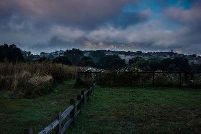 Scenic view of field against cloudy sky