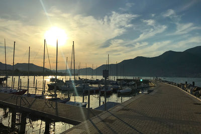 Boats moored at harbor during sunset