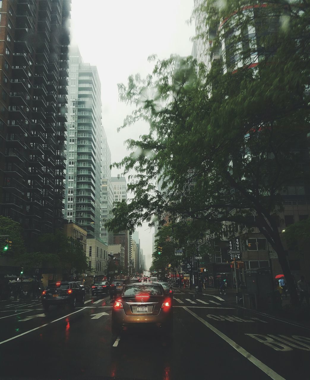 transportation, car, land vehicle, mode of transport, road, street, on the move, city, road marking, traffic, the way forward, tree, building exterior, travel, architecture, built structure, vehicle, high angle view, city street, sky