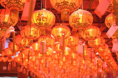 Low angle view of illuminated lanterns hanging at night