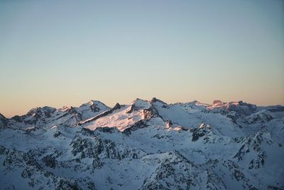 Scenic view of snowcapped mountains against clear sky during winter