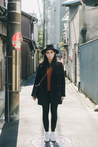 Full length of young woman standing in city