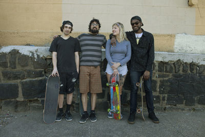 Portrait of two people standing against the wall
