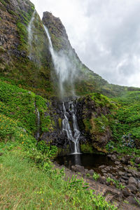 Scenic view of waterfall against sky