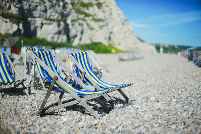 Chairs on beach against sky