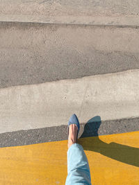 A girl crosses the road through a pedestrian crossing top view