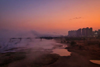 Buildings in city at sunset