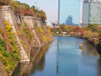 Scenic view of lake amidst buildings against sky