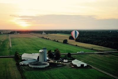 Scenic view of grassy field against sky at sunset