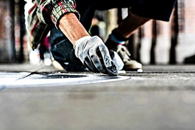 Cropped image of hands with glove making street art